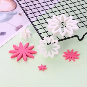Gedetailleerd overzicht van witte bloemvormige fondantsteker en roze suikerbloemen