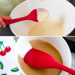 Detailed view of a red silicone spatula stirring smooth cake batter in a white bowl