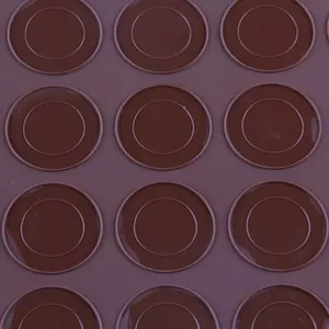 Macro-opname van de cirkelvormige patronen op een bruine siliconen macaron bakmat