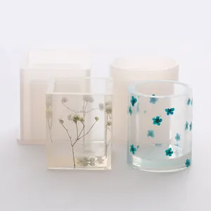 Detail of square and circular silicone molds with finished resin flower pen holders