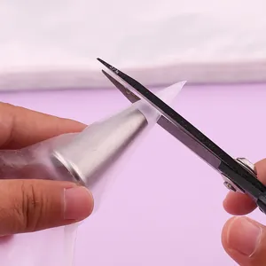 Close-up of cutting the tip of a thick PE disposable piping bag for nozzle insertion.