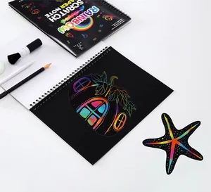 Detail of a rainbow scratch art notebook with a colorful pumpkin drawing and tools.