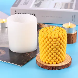 Detailed view of a yellow textured pillar candle and its DIY white silicone mold