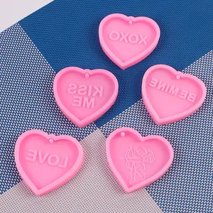 Dettaglio di cinque stampi in silicone rosa a forma di cuore con disegni LOVE e Cupido