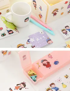Nahaufnahme von süßen Cartoon-Aufklebern auf einer weißen Tasse und einer rosa Box.