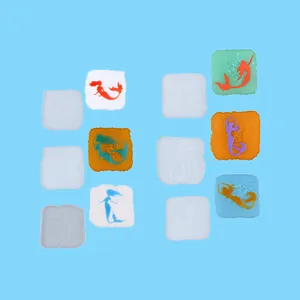 Detail view showing square mermaid silicone molds and colorful resin coasters on blue base.