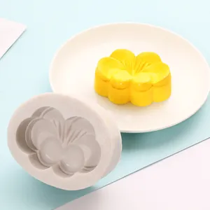 Macro view of flower-shaped silicone mooncake mold with yellow finished cake on a plate