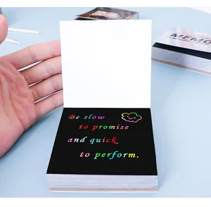 Nahaufnahme von Regenbogen-Kratznotizen mit buntem Motivations-Text auf schwarzem Papier.