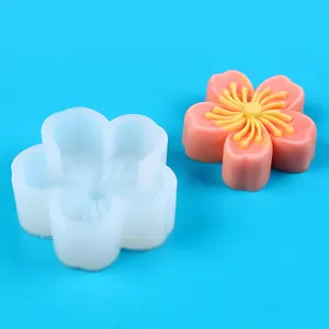 Detailed view of flower-shaped silicone mold with finished pink sakura craft