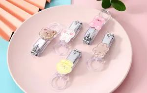 Detail of cute cartoon bear nail clippers with transparent handles on a tray.
