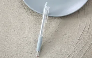 Nahaufnahme eines minimalistischen transparenten Gelschreibers mit grauem Gummigriff