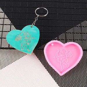 Dettaglio dello stampo in silicone a cuore con Cupido e ciondolo finitura verde acqua.