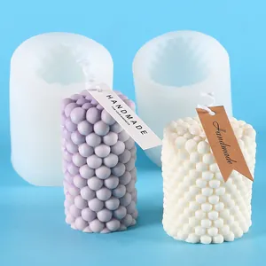 Close-up view of a silicone bubble candle mold alongside finished handmade wax candles