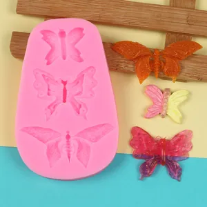 Detailed view of pink butterfly silicone mold with colorful DIY resin crafts.