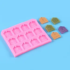 Vista detallada de un molde de silicona rosa con doce cavidades de nombres de meses en forma de casa