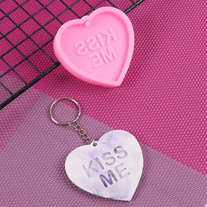 Vista dettagliata dello stampo in silicone a cuore e del portachiavi Kiss Me in resina