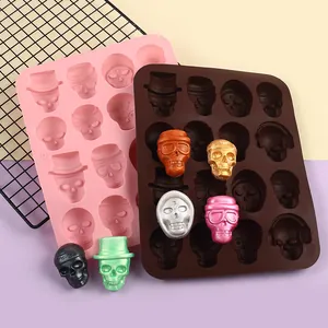 Close-up of diverse skull-shaped silicone molds with colorful finished chocolate candies.