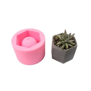 Détail d'un moule en silicone hexagone rose et d'un pot de jardinière en béton fini