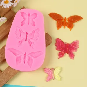 Detailed view of pink butterfly silicone mold with three cavities and finished crafts