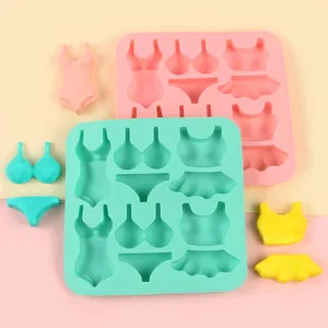 Detailed view of bikini and swimsuit shaped silicone molds with colorful fondant samples