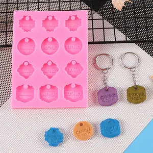 Primer plano de molde de silicona rosa para colgantes DIY con palabras en inglés.