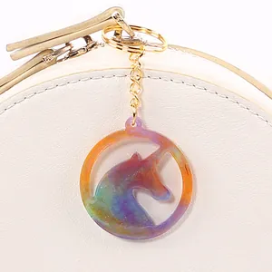 Vista dettagliata di un ciondolo unicorno fatto a mano in resina glitterata arcobaleno
