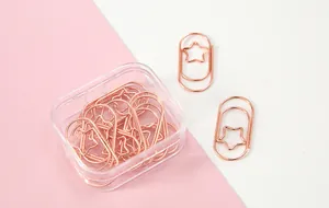 Nahaufnahme der roségoldenen sternförmigen Metall-Büroklammern in einer Box