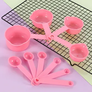 Macro view of 10-piece pink plastic measuring spoon and cup set for baking and cooking