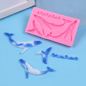Vue détaillée du moule en silicone rose pour baleines et vagues avec pièces bleues.