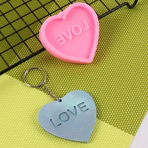 Vista dettagliata di uno stampo in silicone a cuore e portachiavi in resina LOVE