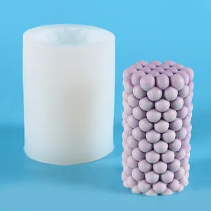 Detailed view of white silicone mold and purple bubble texture candle on blue background