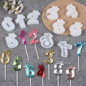 Close-up of crown number silicone molds and finished metallic candles for cake decor.