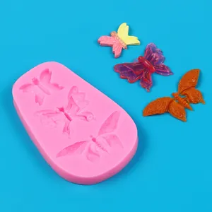 Detail view showing a pink silicone mold with three unique butterfly-shaped cavities