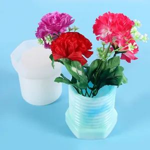 Close-up showing the threaded silicone mold alongside a finished blue resin vase with flowers