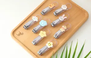 Close-up of a variety of cute cartoon character nail clippers displayed on a wooden tray