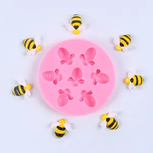 Vista detallada del molde de silicona rosa con 7 cavidades de abejas y abejas terminadas