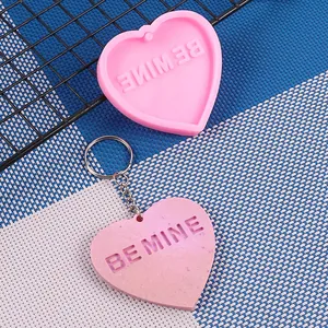 Vista dettagliata di uno stampo in silicone a cuore rosa e portachiavi in resina finito