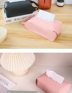 Detail view of pink leather tissue box with handle and snap button on wooden table