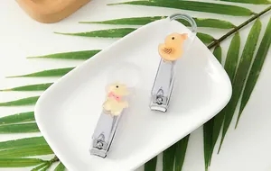Close-up of cute character nail clippers with yellow duck and white bear charms in detail