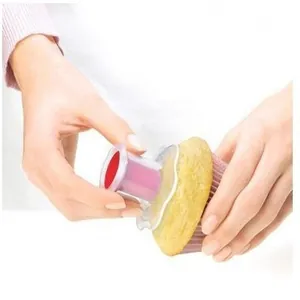 Primer plano de un descorazonador de cupcakes manual quitando el centro de un pastelito