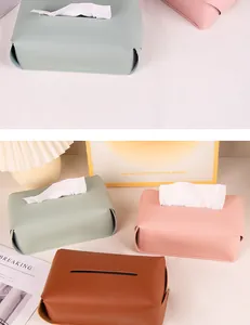 Detail view of soft leather tissue boxes in pastel green, pink, and brown colors