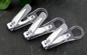 Primo piano di tre tagliaunghie minimalisti con manici trasparenti su pietra scura.