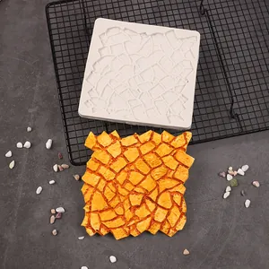 Vista de detalle del molde de silicona blanco con textura de corteza y fondant naranja hecho
