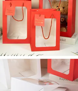 Dettaglio di sacchetti regalo di lusso in carta rossi e bianchi con finestra trasparente