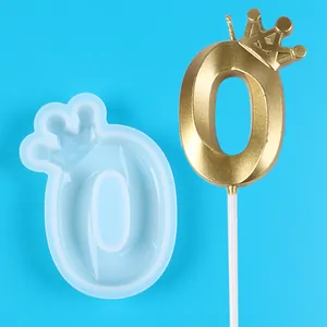 Close-up view of crown number 0 silicone mold alongside finished gold birthday candle detail
