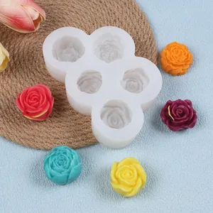 Nahaufnahme einer Silikonform für 5 Rosen mit bunten fertigen Wachsblumen.