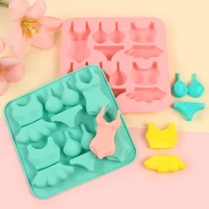 Close-up of bikini and swimsuit silicone molds with colorful fondant cake decorations.