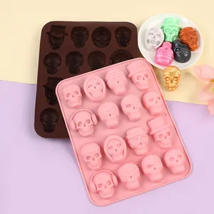 Close-up detail of pink and brown silicone molds with various Halloween skull shapes for chocolate