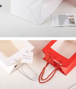 Vista macro dettagliata di sacchetti regalo di carta bianchi e rossi con finestra