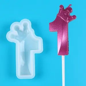 Close-up of a number 1 crown silicone mold alongside a pink glittery finished topper